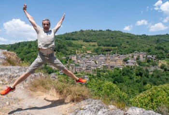 Saltando en el mirador de Le Bancarel con la vista de Conques